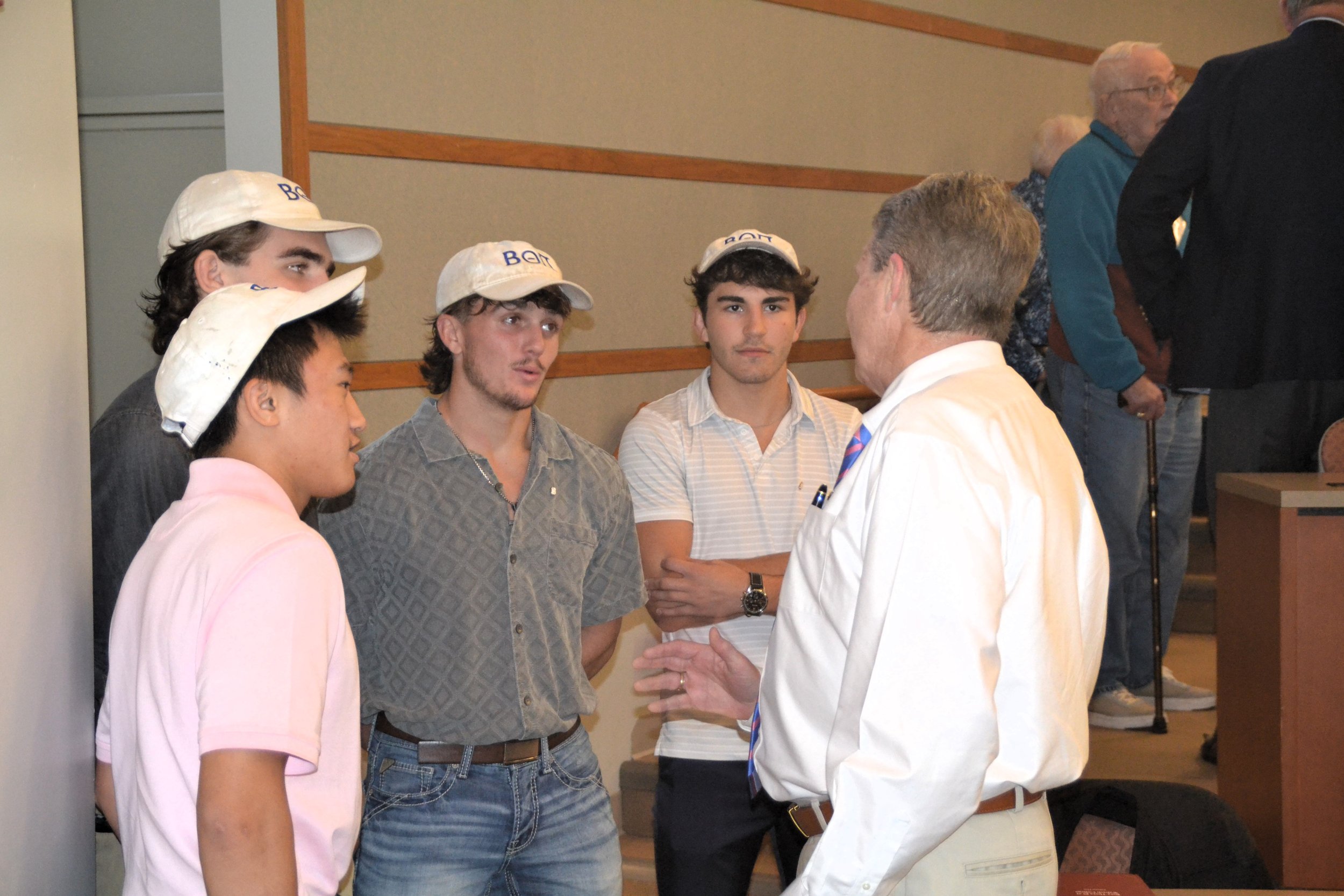  Jon Myers ‘81 chats with Liam Krueger '27, Mike Kopecky '27, Nathan Powell '27, and Isaac Ward '27 following his presentation. 