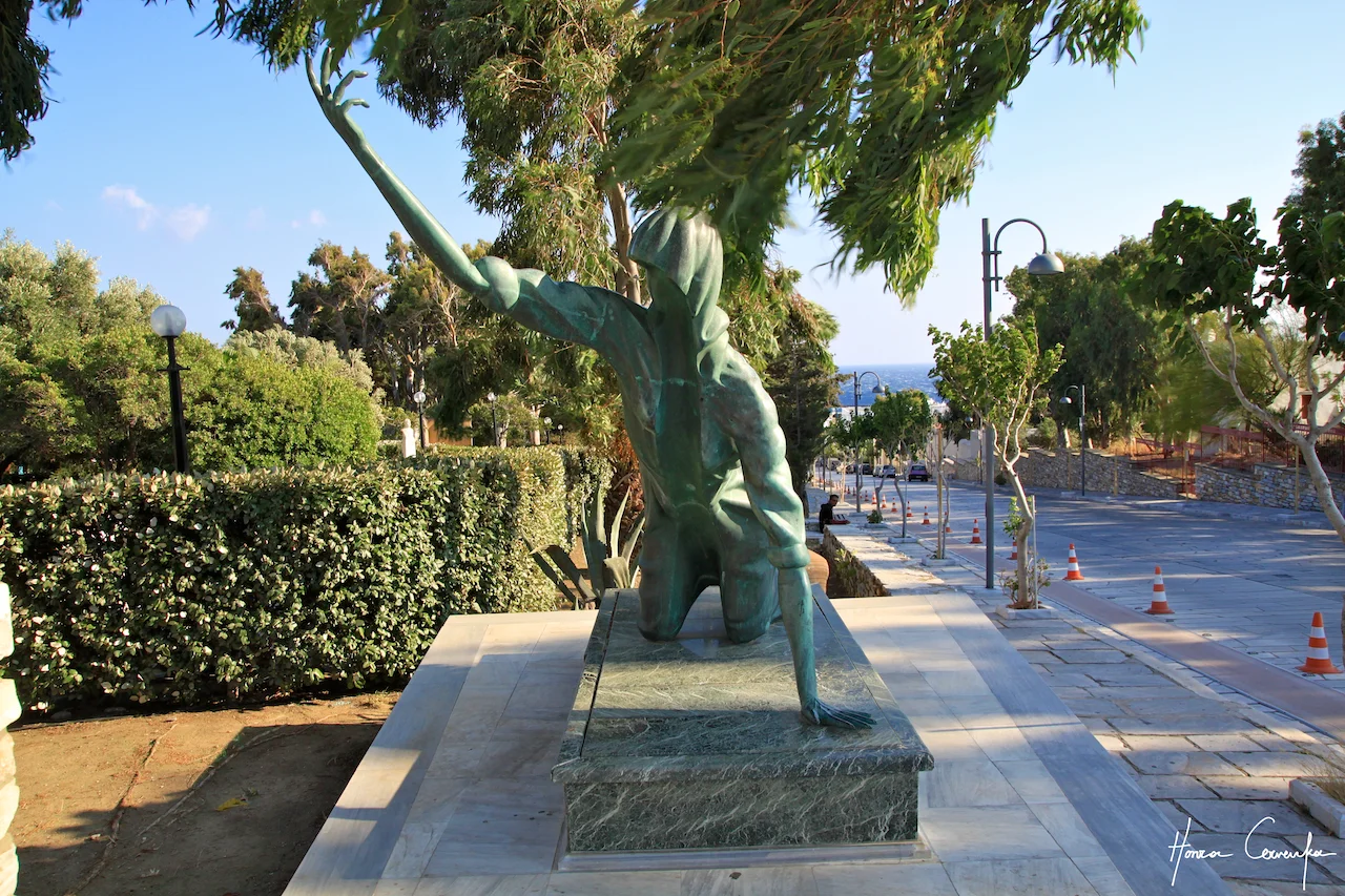 An odd-shaped statue leading to the church--some serious arms!
