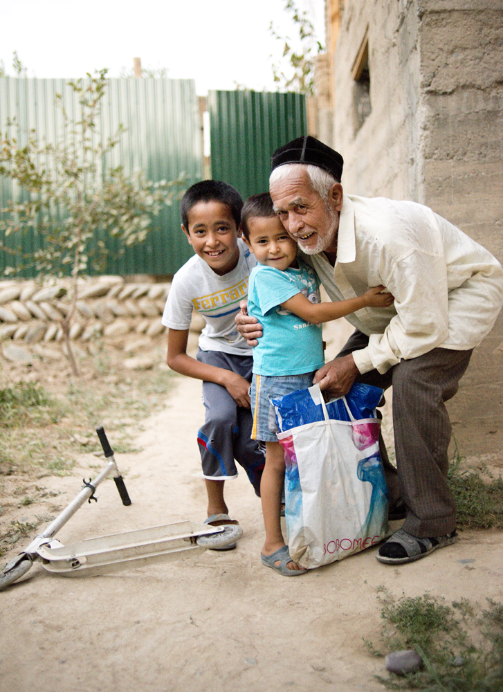 Isroil Isakov, the father of one of my co-workers, embraces two of his many grandchildren as he returns from working in the fields near the predominantly Uzbek city of Aravan on the border in Southern Kyrgyzstan. Despite his age, he says he couldn&#…