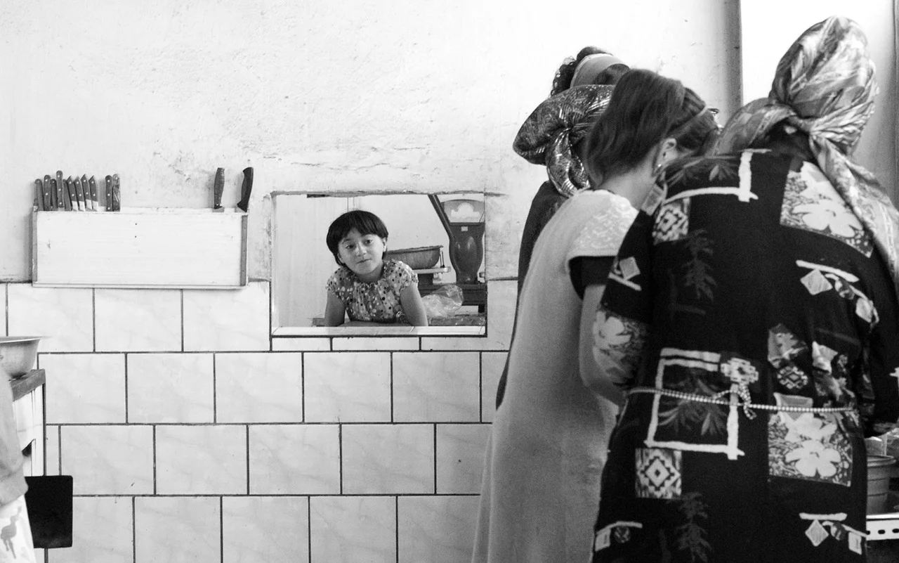 A young girl watches older women prepare food through a serving window in the kitchen of an Uzbek Chaihana in Southern Kyrgyzstan.
I had dinner with a group of MSF security guards and mechanics in a separate room.
