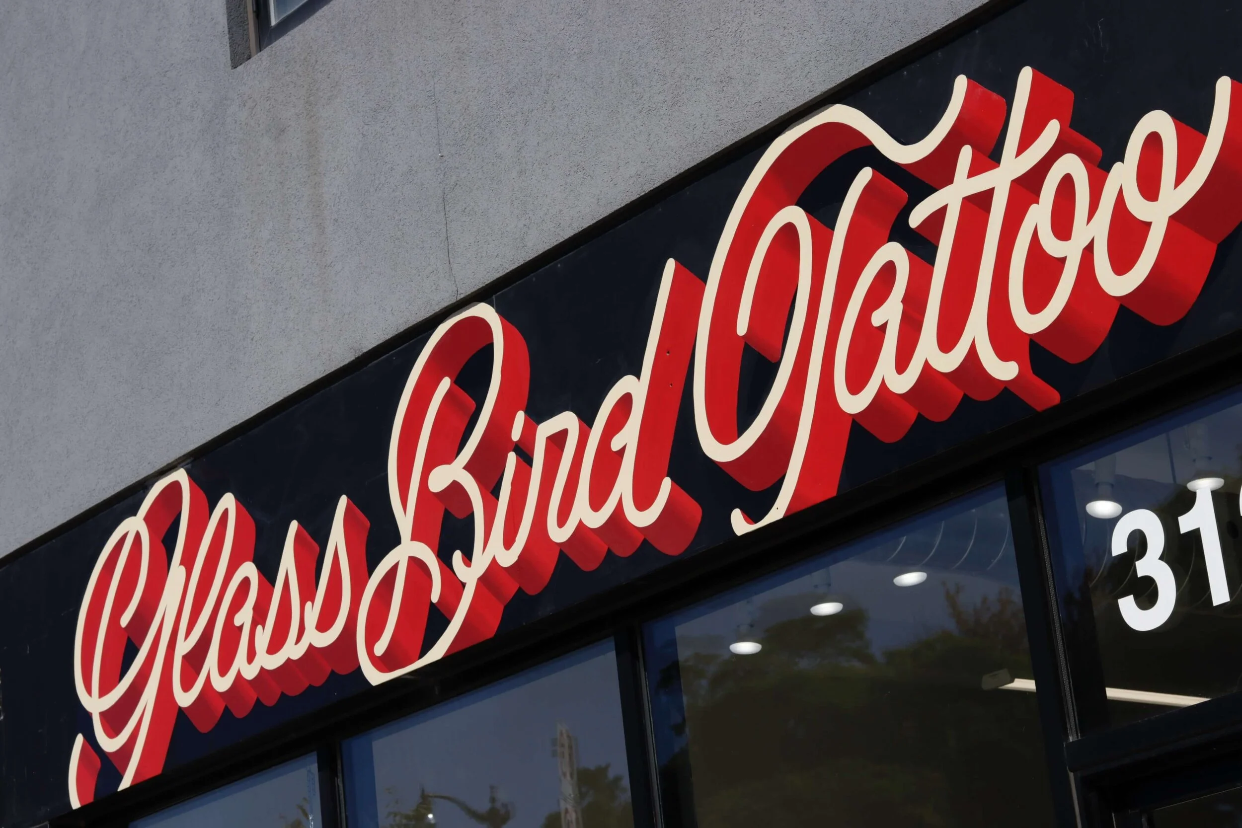  Close up of finished handpainted store sign at GlassBird Tattoo in Toronto  