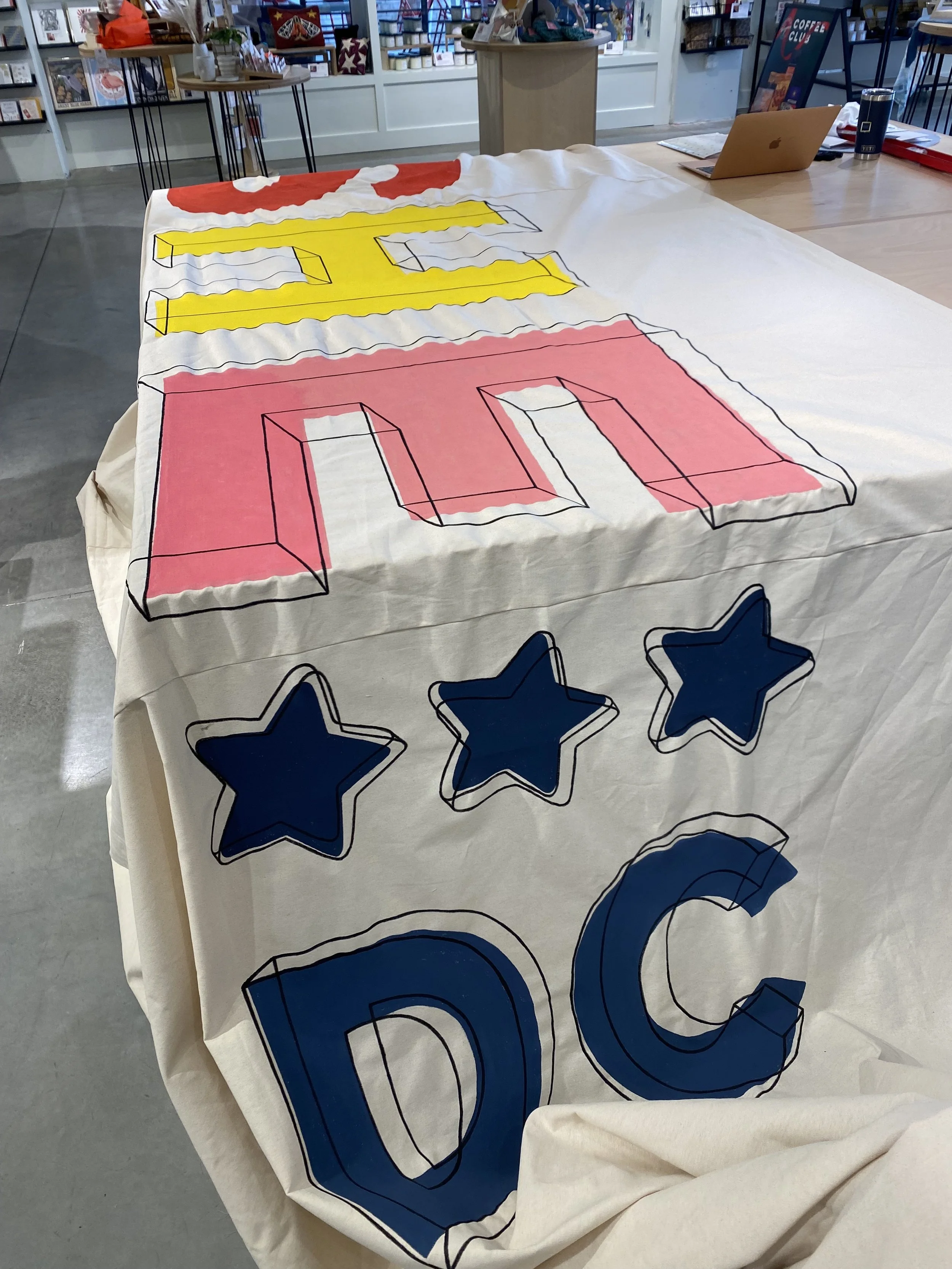 Hand painting the She DC logo for their March 2025 opening.