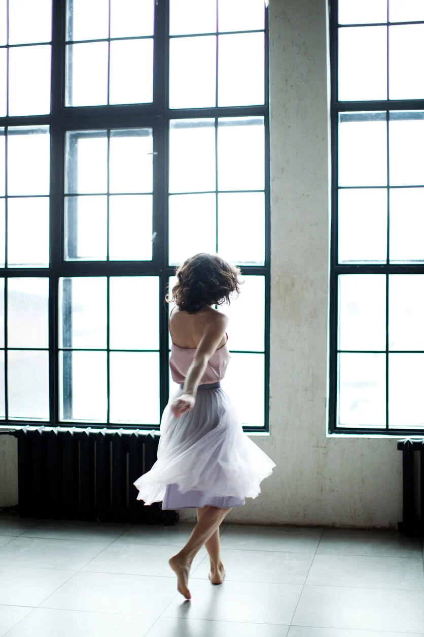 Twirl. Woman in a dress doing a spin in a dance studio