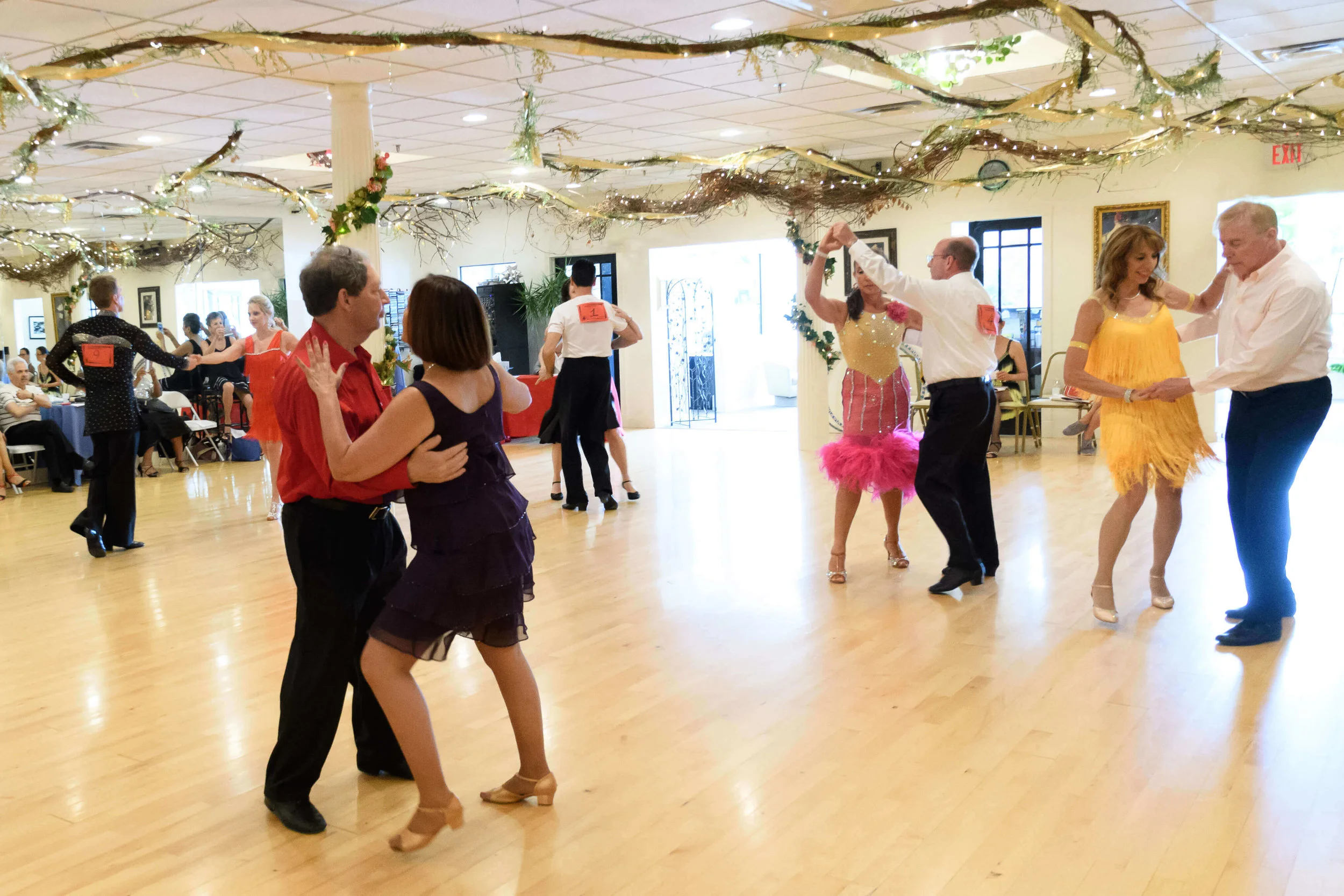 Couples dancing rumba at a studio dance competition