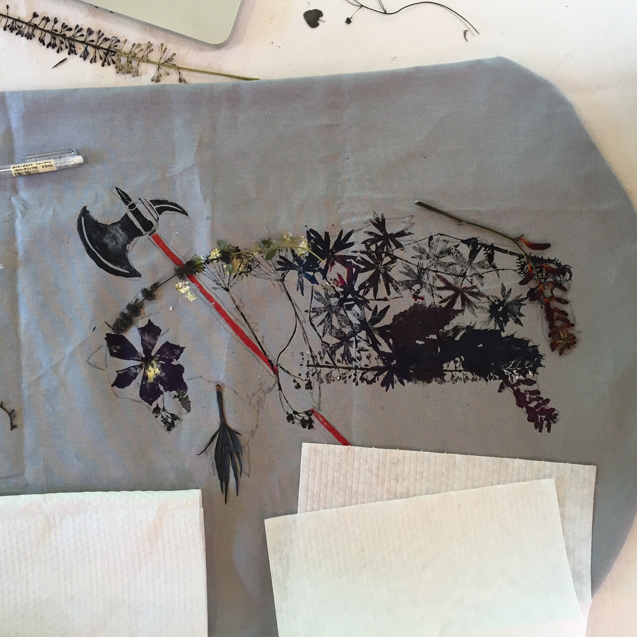 After choosing which pressed plants I want to use to compose the bear, I start to paint each specimen with fabric paint and the press it onto the fabric with a paper towel on the back to absorb any excess ink.
