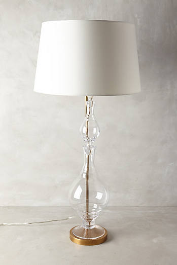 A Glass base allows for height, yet does not take away from the space. Hourglass Lamp by Anthropologie