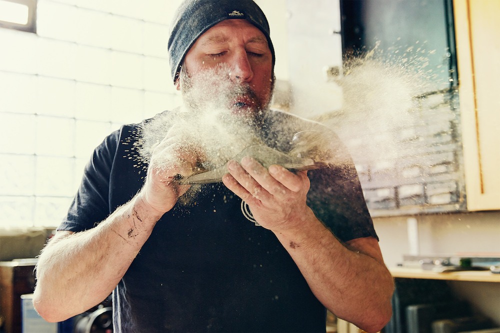 Woodshop-worker-blowing-dust-off.jpg