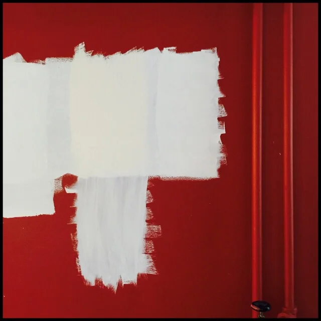 Red wall with white ideas and two pipes