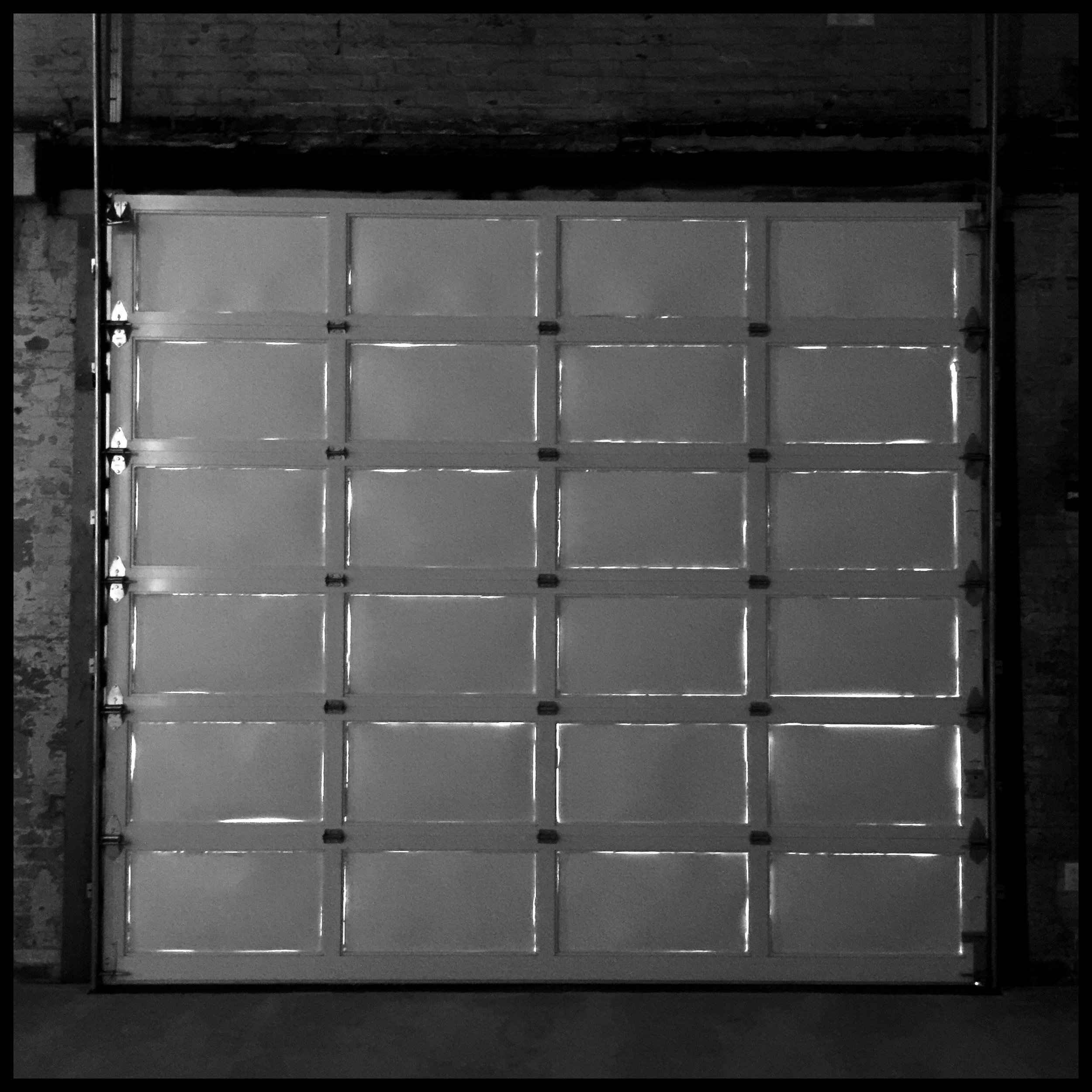 Daylight at edges of opaque-painted glass panes in old garage door