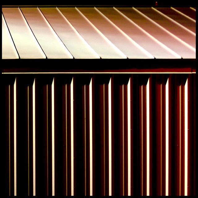 Sharp shadows on corrugated shed after dark