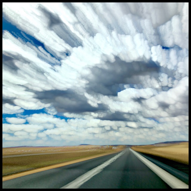 Open highway at speed under dappled sky, slow shutter