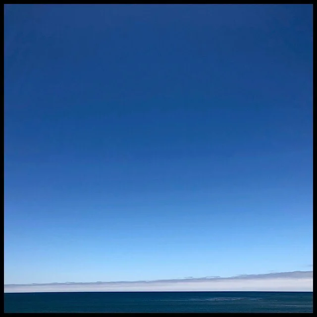 Tilted cloud line on ocean horizon