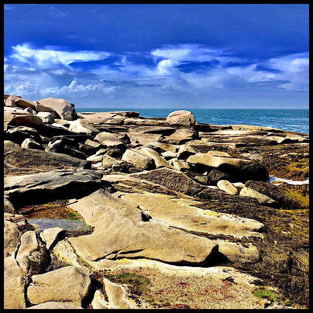 Ocean calm between tormented land and sky