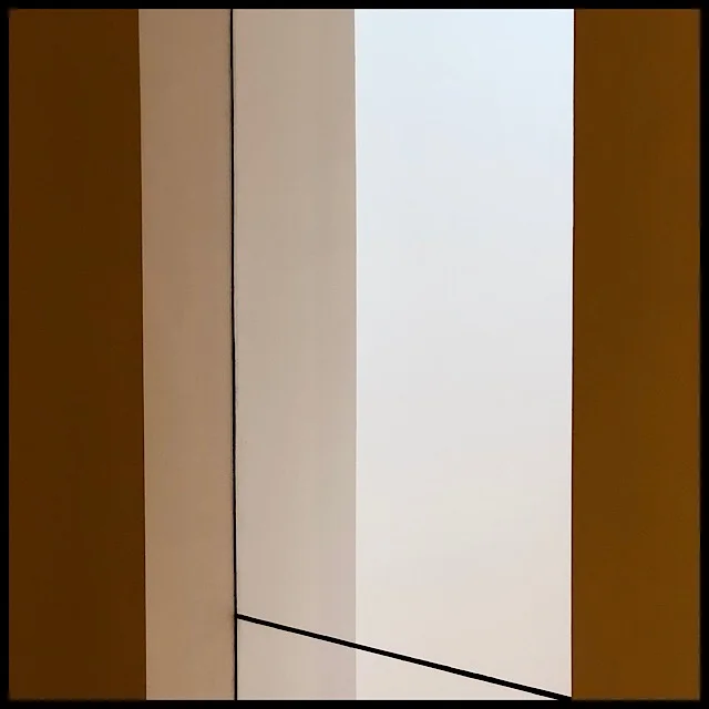 Three-storey glass partition connecting two walls