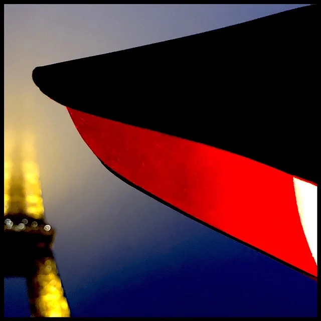 Red traffic light detail with curious iron tower in evening fog