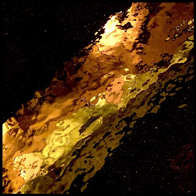 Illuminated facade by night reflected in rainy sidewalk