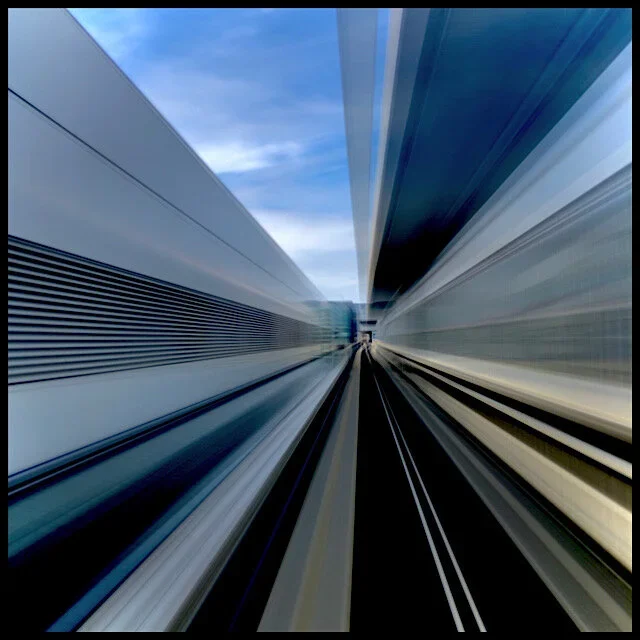 Radiating perspective: rear window view from airport train, slow shutter