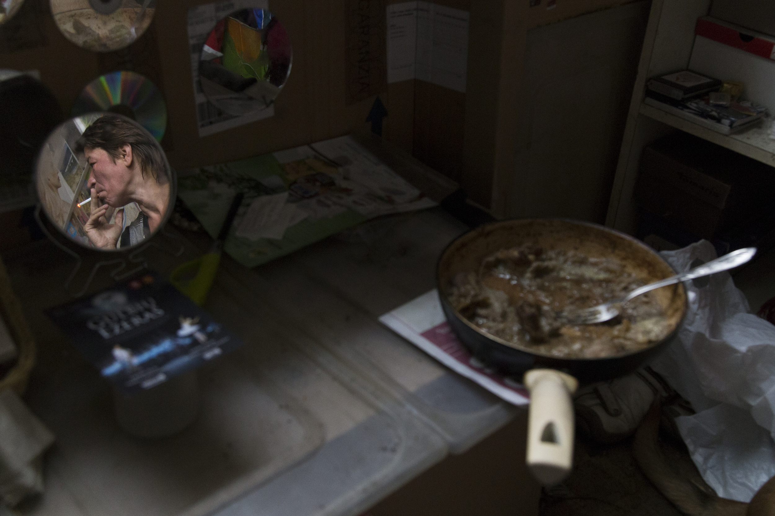 Svetlana, 51, smokes in her room located in an abandoned monastery hospital where she lives with her husband on Aug. 18, 2014, in Vilnius, Lithuania. Living right in the center of the city, where there are more people and tourists, they do not need to travel far when asking for money; however, their location has its disadvantages. “One time I made sandwiches and salad and left the room for a bit. I returned and found the food and the water we were saving missing. It had disappeared. We have a dog now and it lets us know if there are intruders,” said Svetlana.