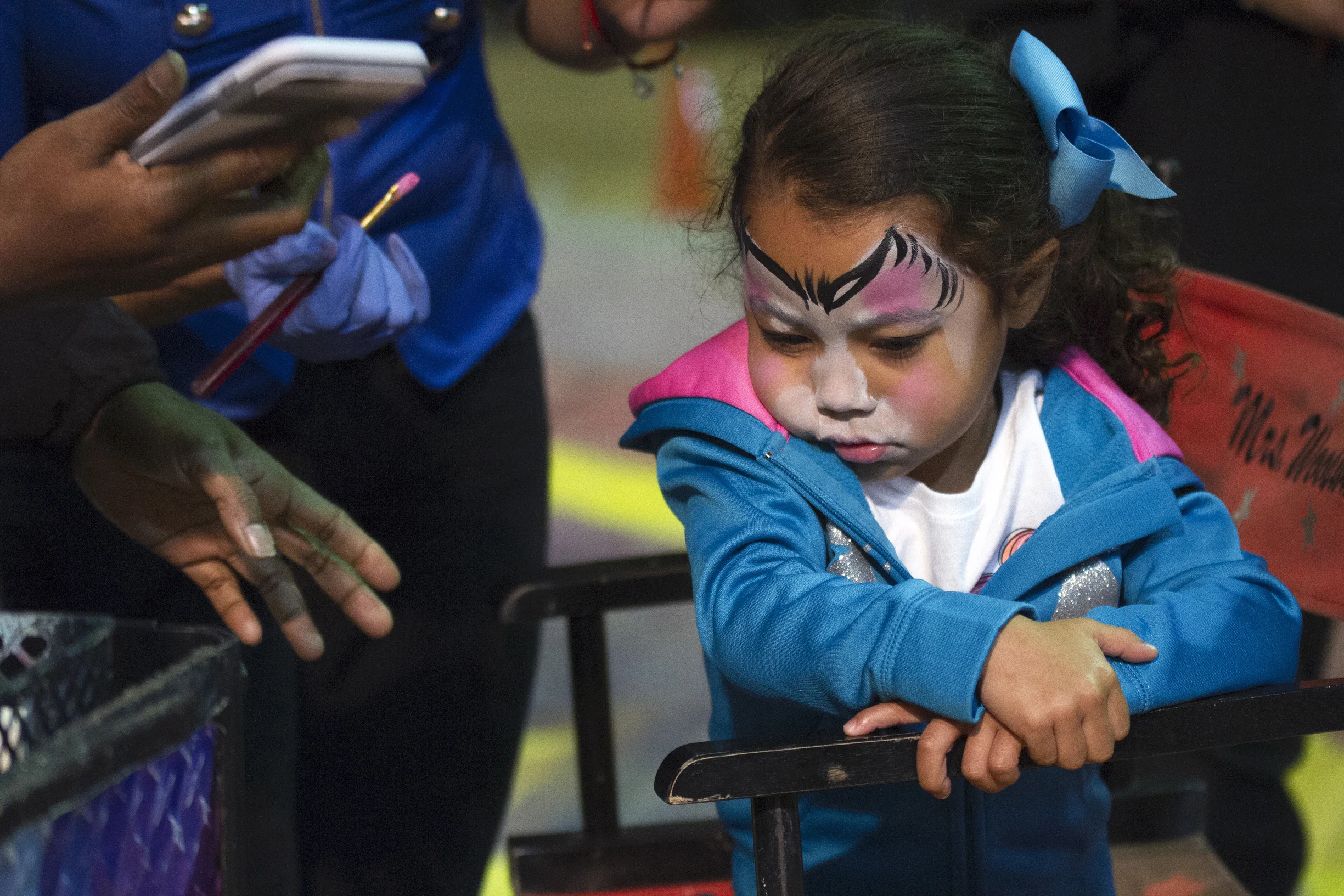 Peighsyn Lemke, 3, refuses the finishing touches of her kitten face paint.