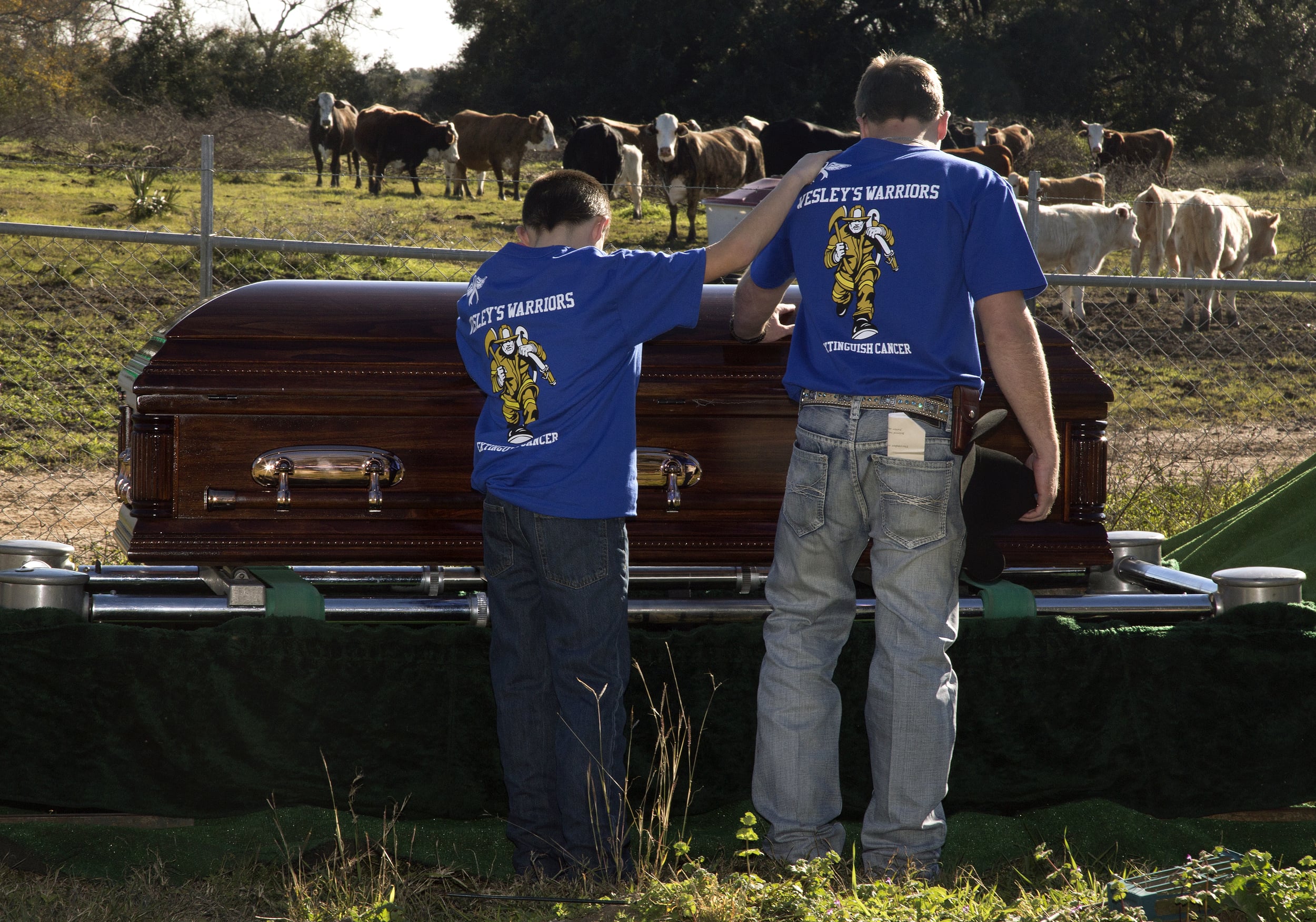 Mourners touch the casket of John Wesley Hendry on Tuesday, January 12, 2016, at Red Bluff Cemetery in Lolita, Texas. Hendry was the fire chief of the Lolita Fire Department and died at the age of 46 of cancer to the brain, lungs, and bones. This is the first fireman's funeral in Jackson County. "I have this hole in my heart that I don't think I will ever be able to fill. His name will go on with his children and grandson," said Betty Conn Hendry, the mother of John Wesley Hendry.