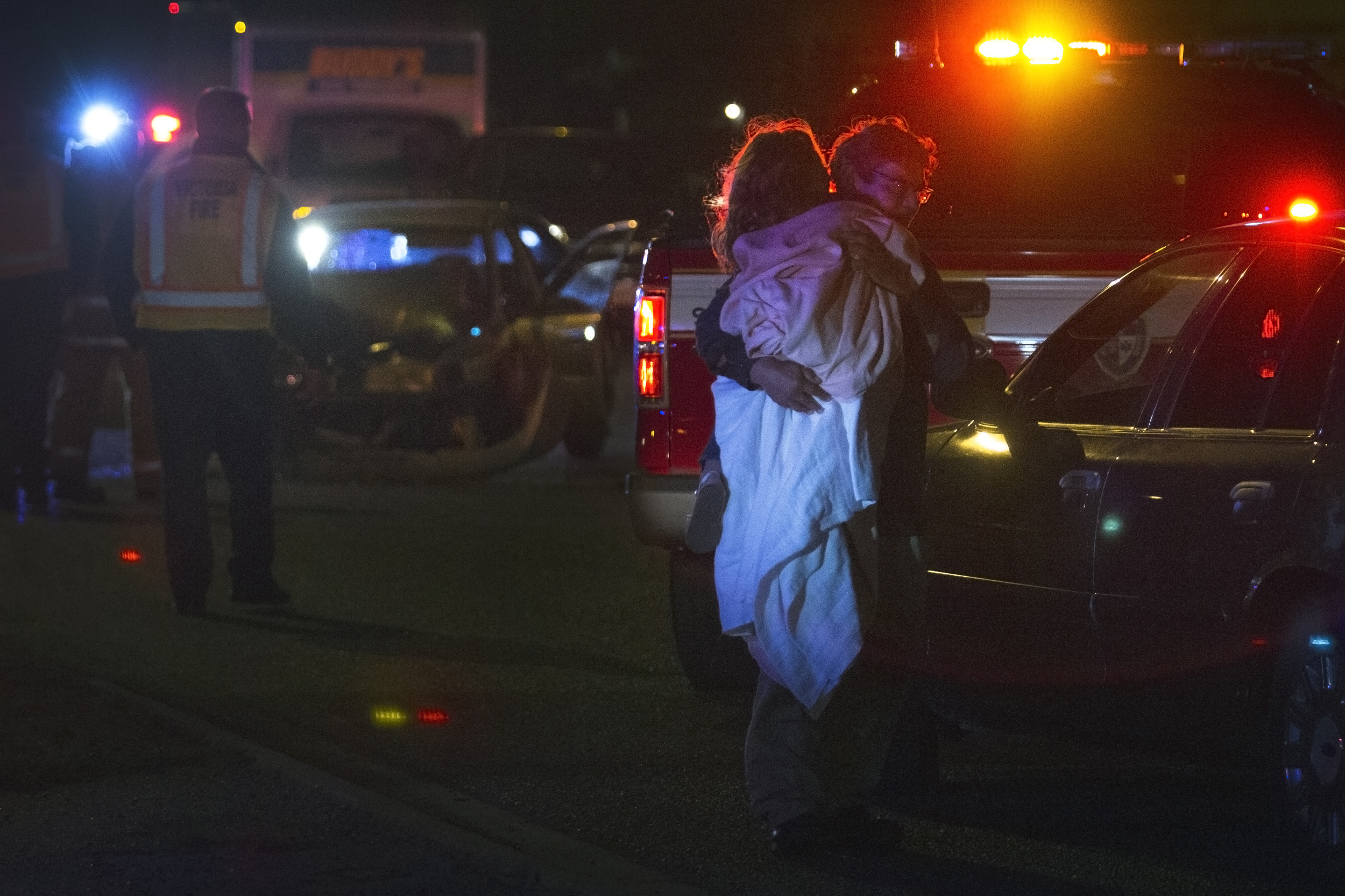 A young girl is comforted at the scene of a collision between a pickup truck and sedan after the truck failed to yield at an intersection on Friday, February 5, 2016, in Victoria, Texas. There were five passengers in the sedan, four of which were children. The pickup truck had three passengers. One child and the driver of the sedan were transported to the hospital.