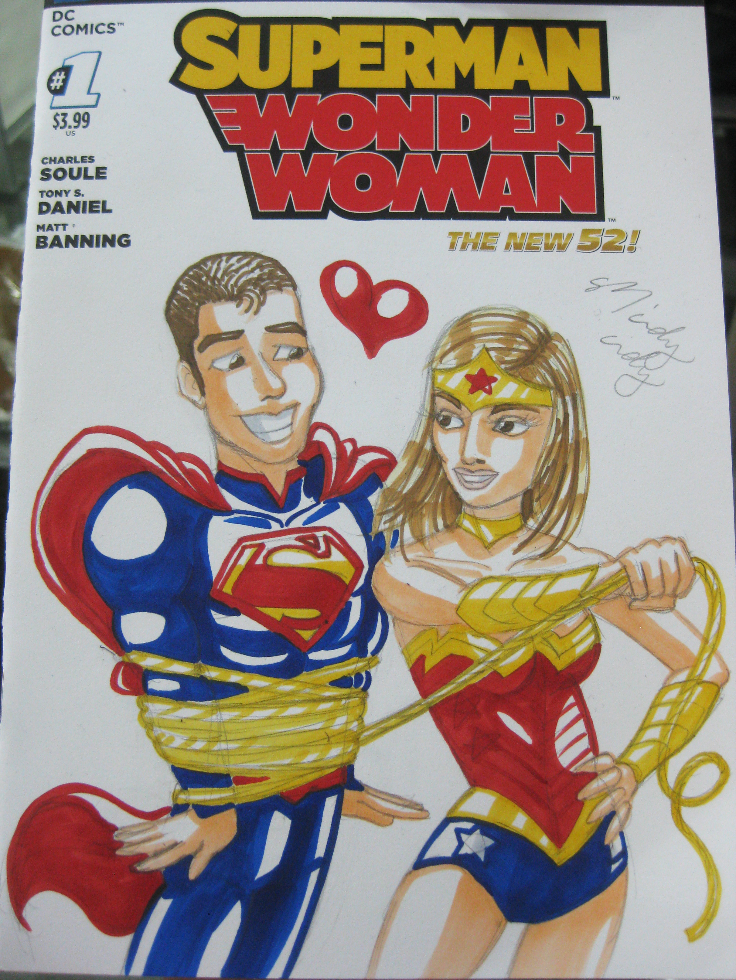 One cool thing about NYCC is that Marvel and DC make special blank covers for some comics for artists to draw on! All this guy said was "draw me as Super Man and my wife as Wonder Woman." This is the quirky kind of drawing you get :) He was like "OMG that's just like my marriage!!" haha, Mindy Indy knows... :)
