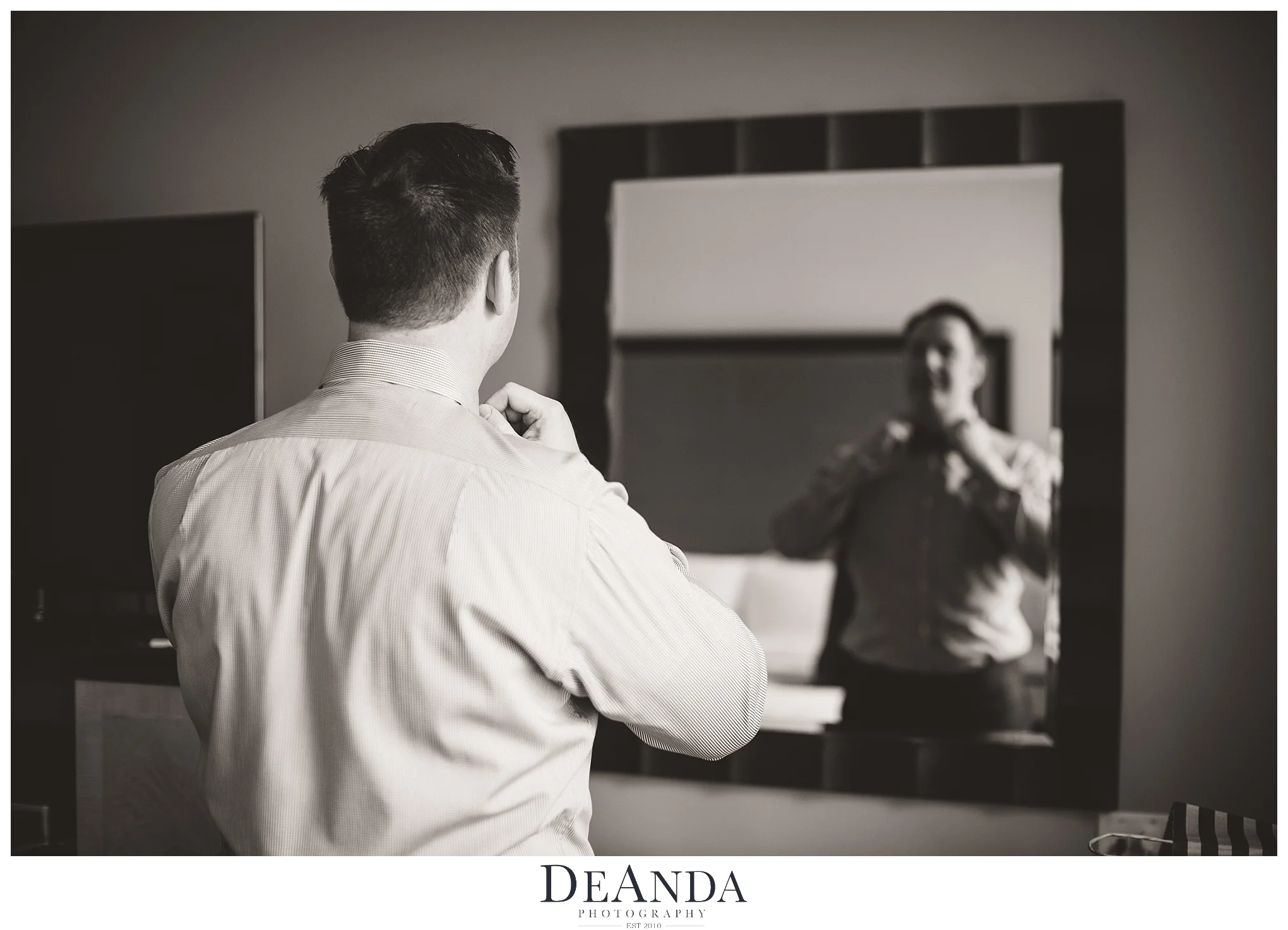 buttoning up shirt in mirror getting ready for chicago wedding at the Gwen