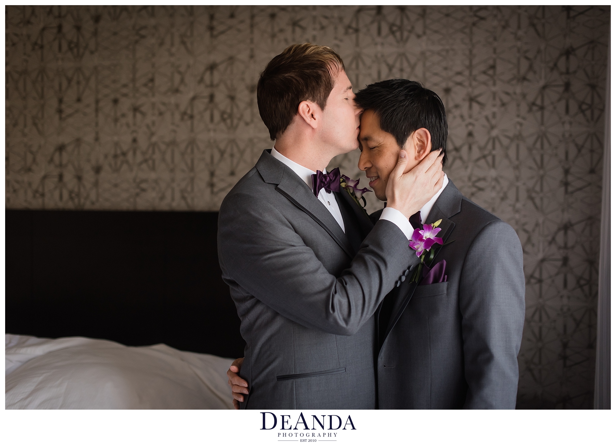 two grooms kissing in hotel room