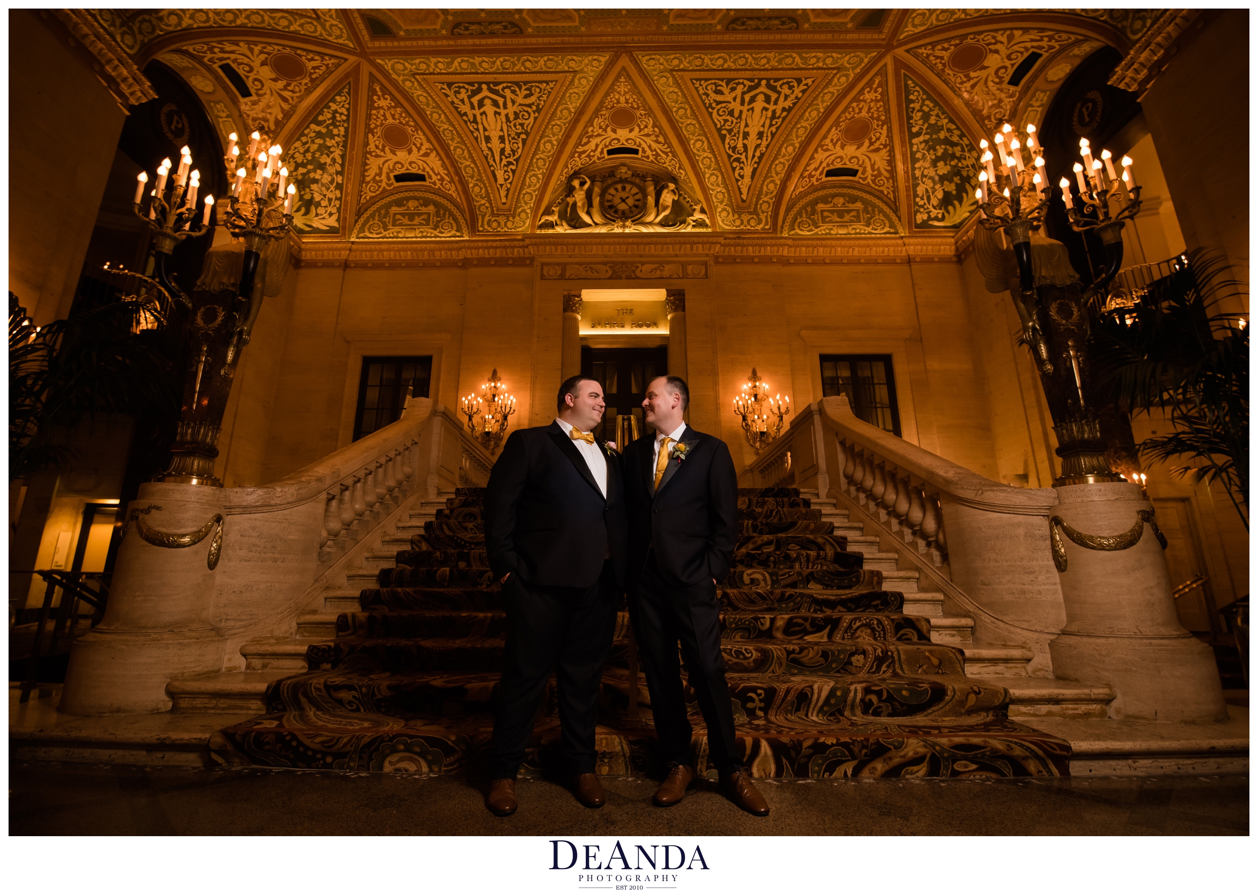 grooms together at palmer house hotel on stairs