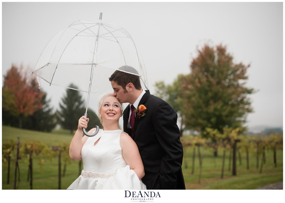 bride and groom under an umbrella at acquaviva winery in maple park