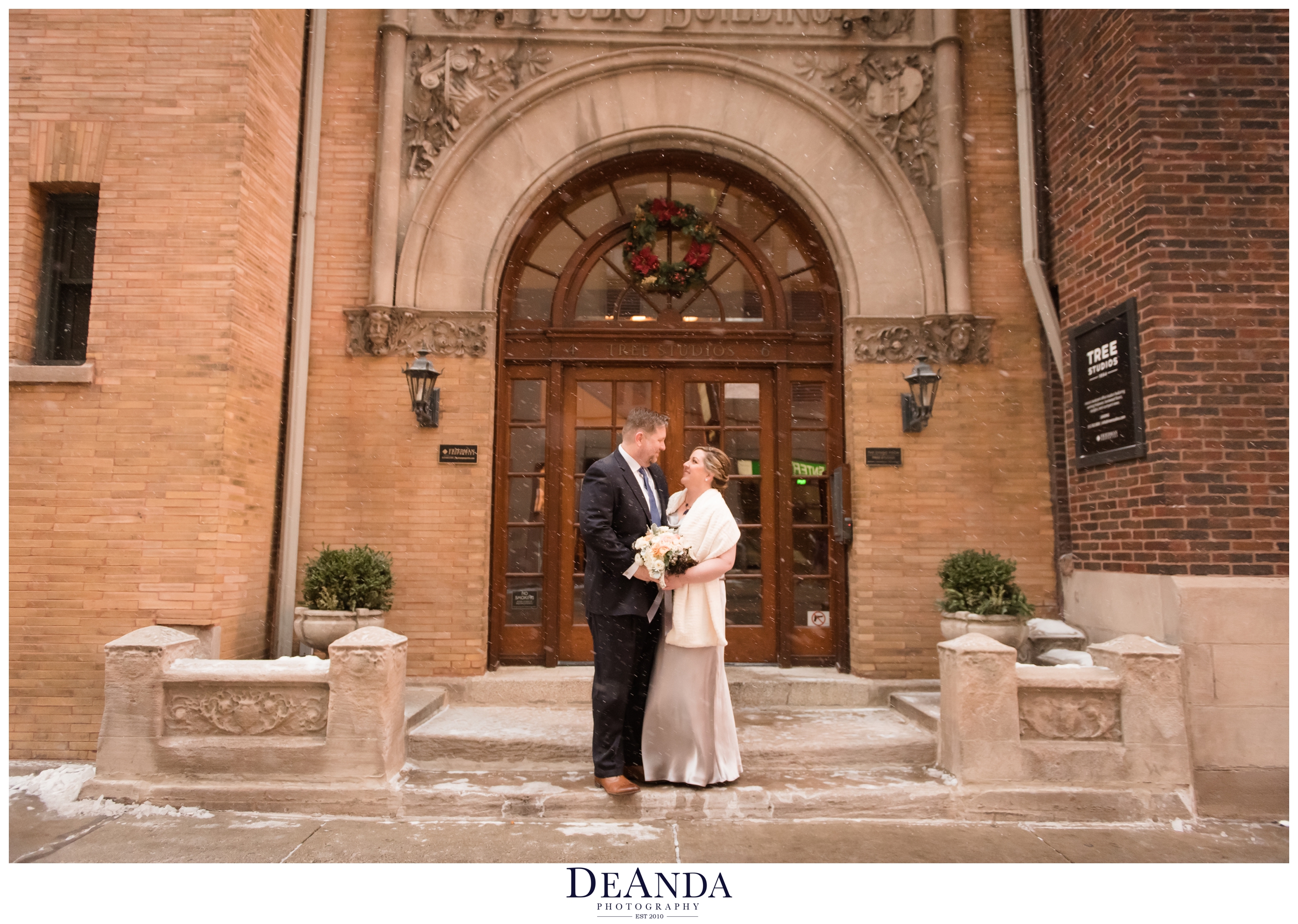 snowing portraits of bride and groom outside tree studios 