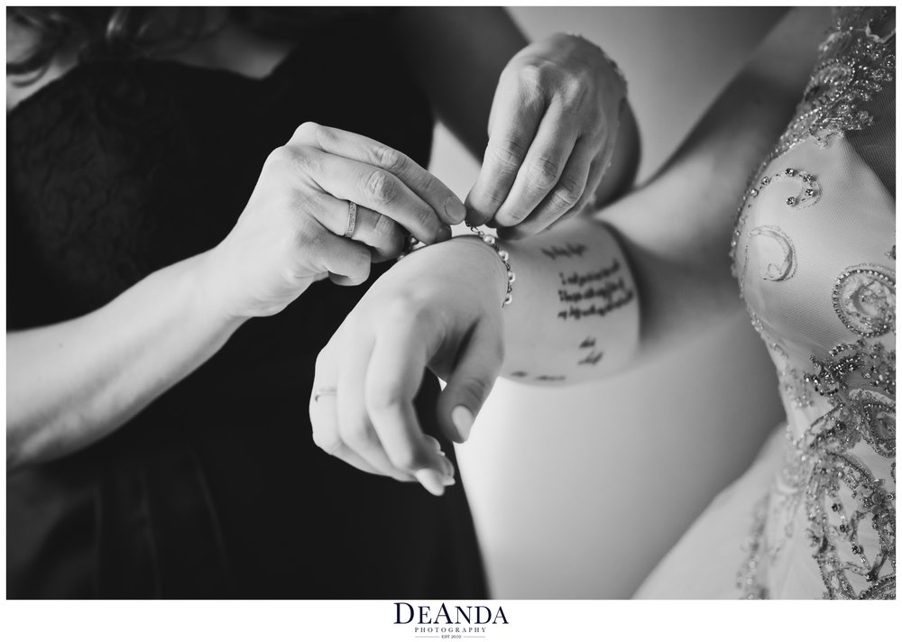 bride having a bracelet put on by a bridesmaid