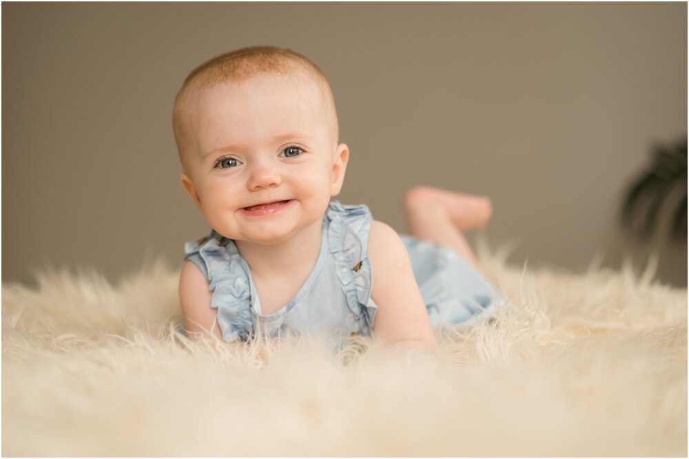 smiling 1 year old on bed