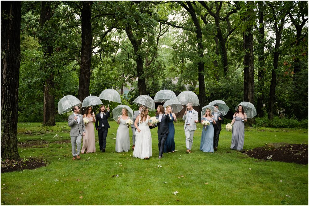 wedding party walking with umbrellas