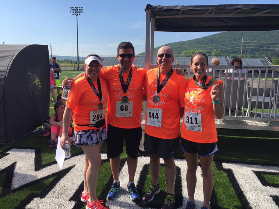 L-R) Randi Hewit (president), Mike Burns (chair, investment committee), John Sirianni (finance officer), and Katie McConville (program assistant) after the 2016 GlassFest 8K presented by the Community Foundation.