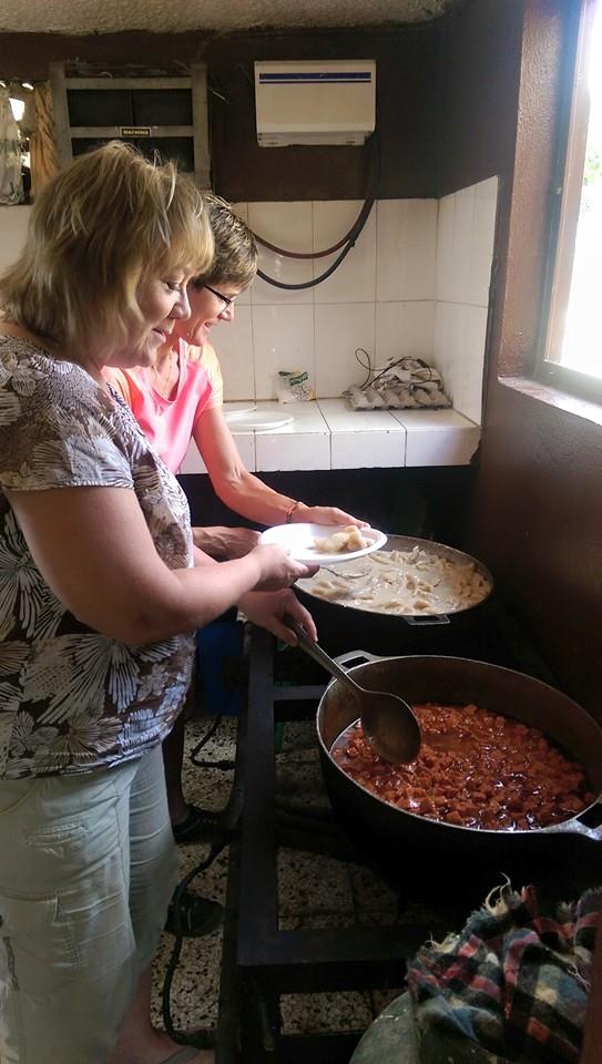 Carol Aase and Lisa Malmstrom serve lunch at one of the mission locations.