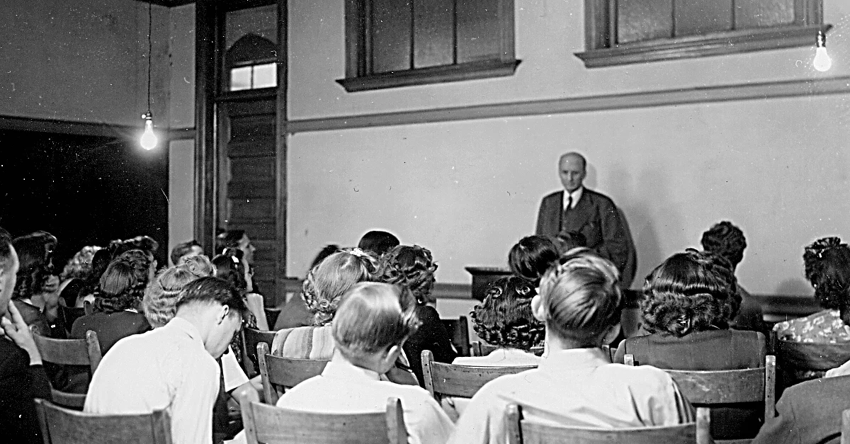 S.L. Klyve stands in front of his class in the 1940s as they practice a written exercise in his Bible course.