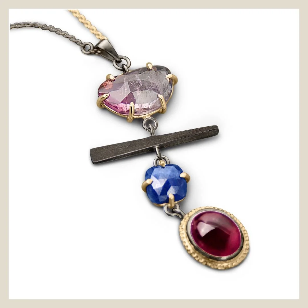 a necklace pendant made by eatmetal fine jewelry collection with gemstones