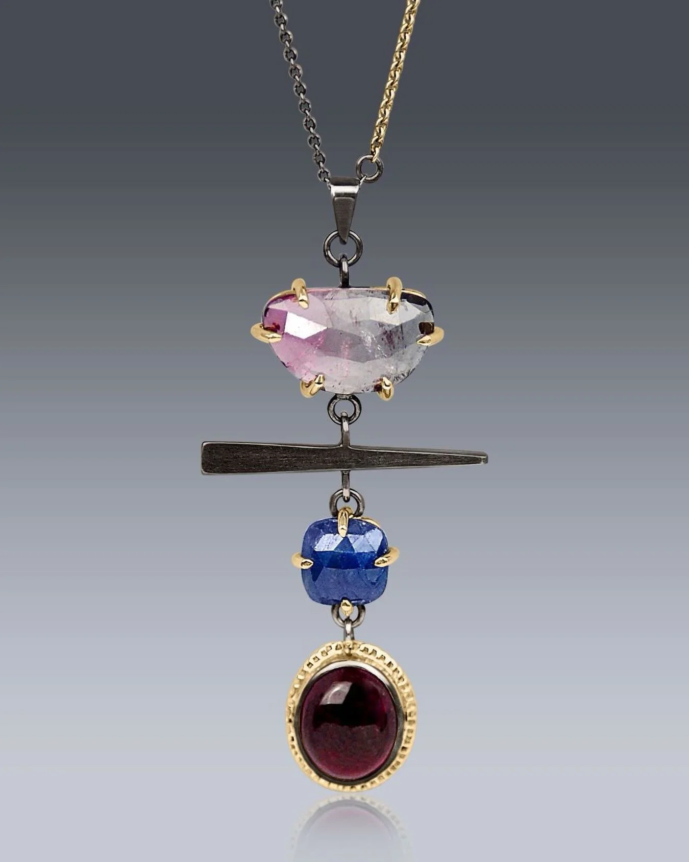 Walking Fern Necklace 
this one-of-a-kind, mixed-metal and gemstone necklace.
It features a stunning trio&mdash;a graduated rose-cut tourmaline, a deep blue square rose-cut sapphire, and a oval pink cabochon&mdash; the top 2 gemstones are prong-set i