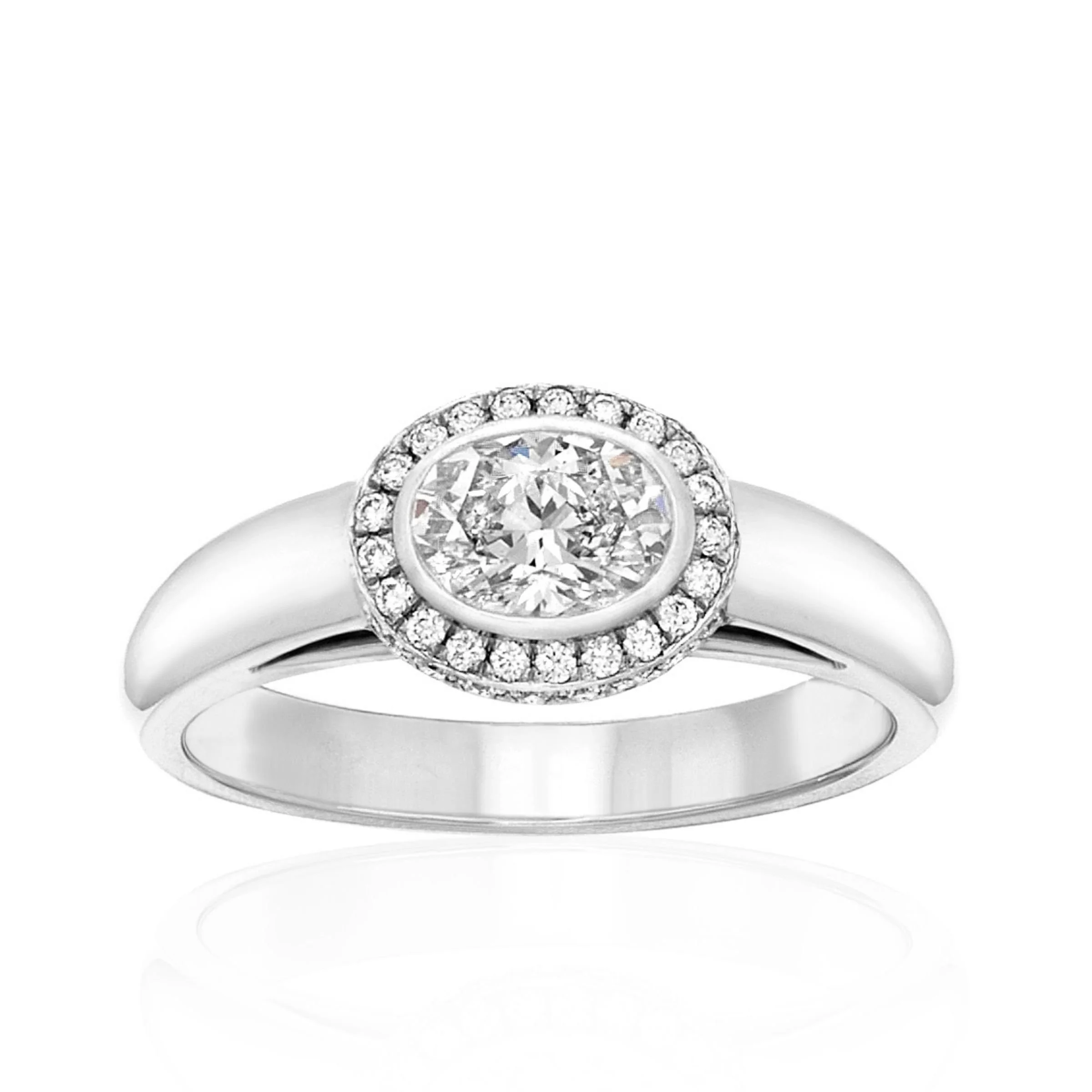 A modern platinum oval diamond bezel-set center stone with halo of micro pave set diamonds on top and around the center stone engagement ring with a thick domed half round band