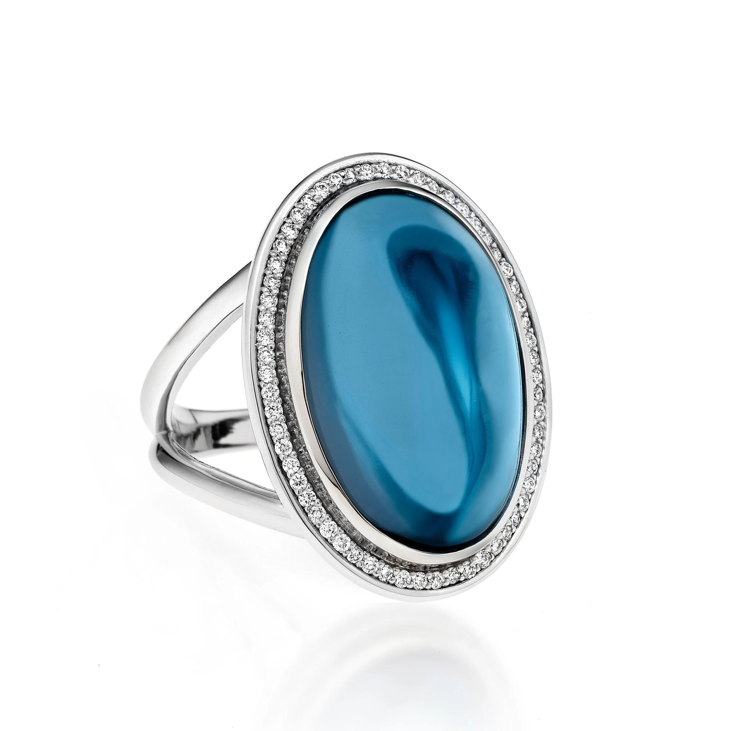 A contemporary 14k white gold oval blue topaz cabochon ring featuring glittering diamond halo micro pave set border and an architectural split band ring