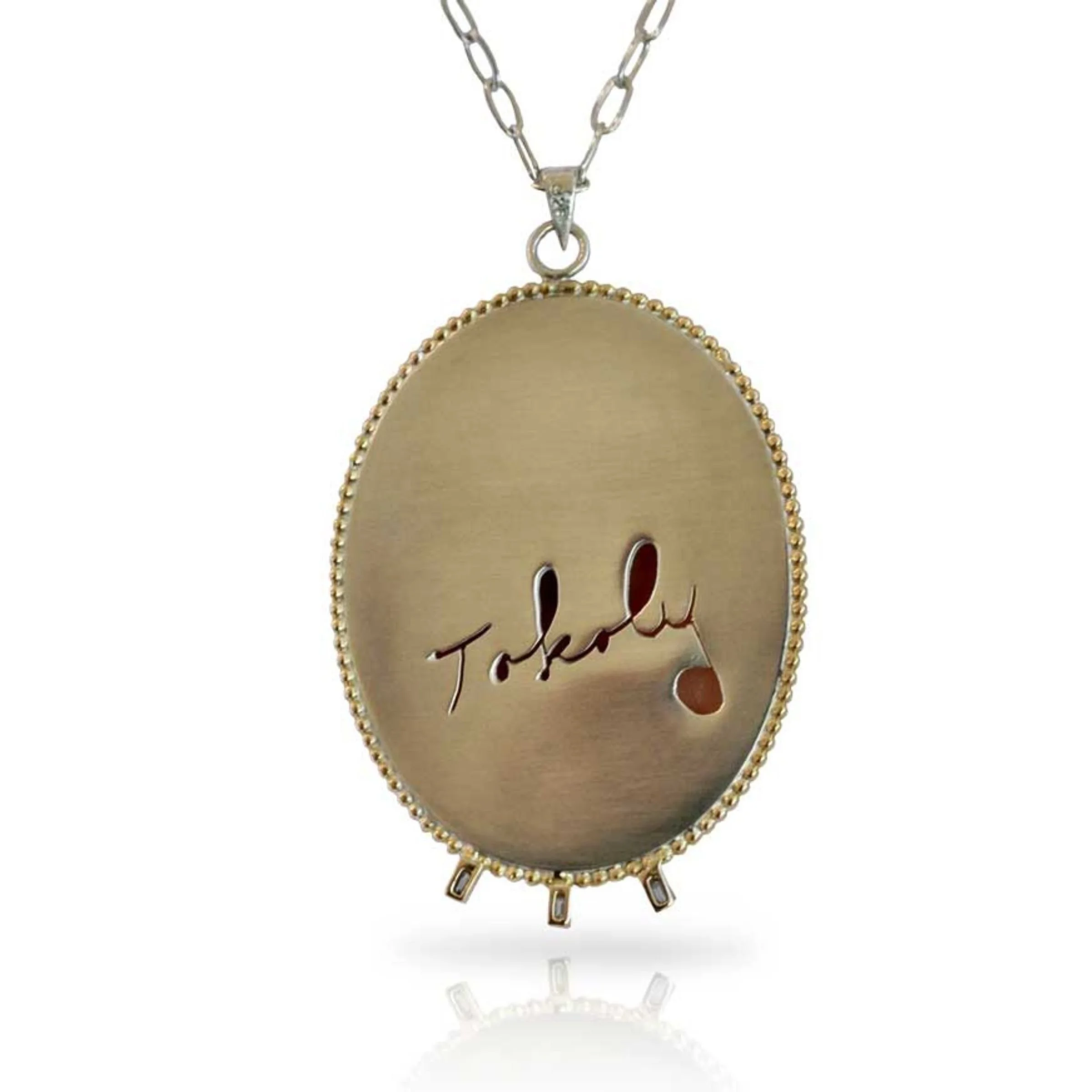 Heirloom Redesign Hand-carved carnelian shell cameo necklace -The reverse side of pendant showing a matte gold backplate hand cut with the replica of script signature "Tokoly," surrounded by a beaded border.