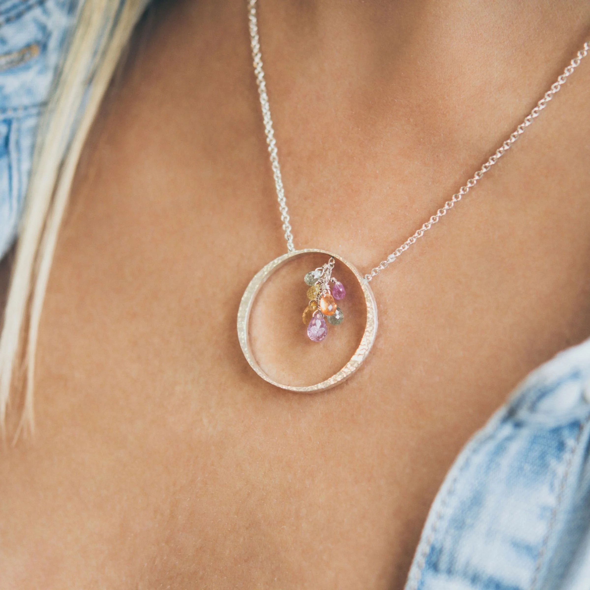 Woman wearing handcrafted EatMetal sterling silver mini circle necklace with multi-color briolette sapphires