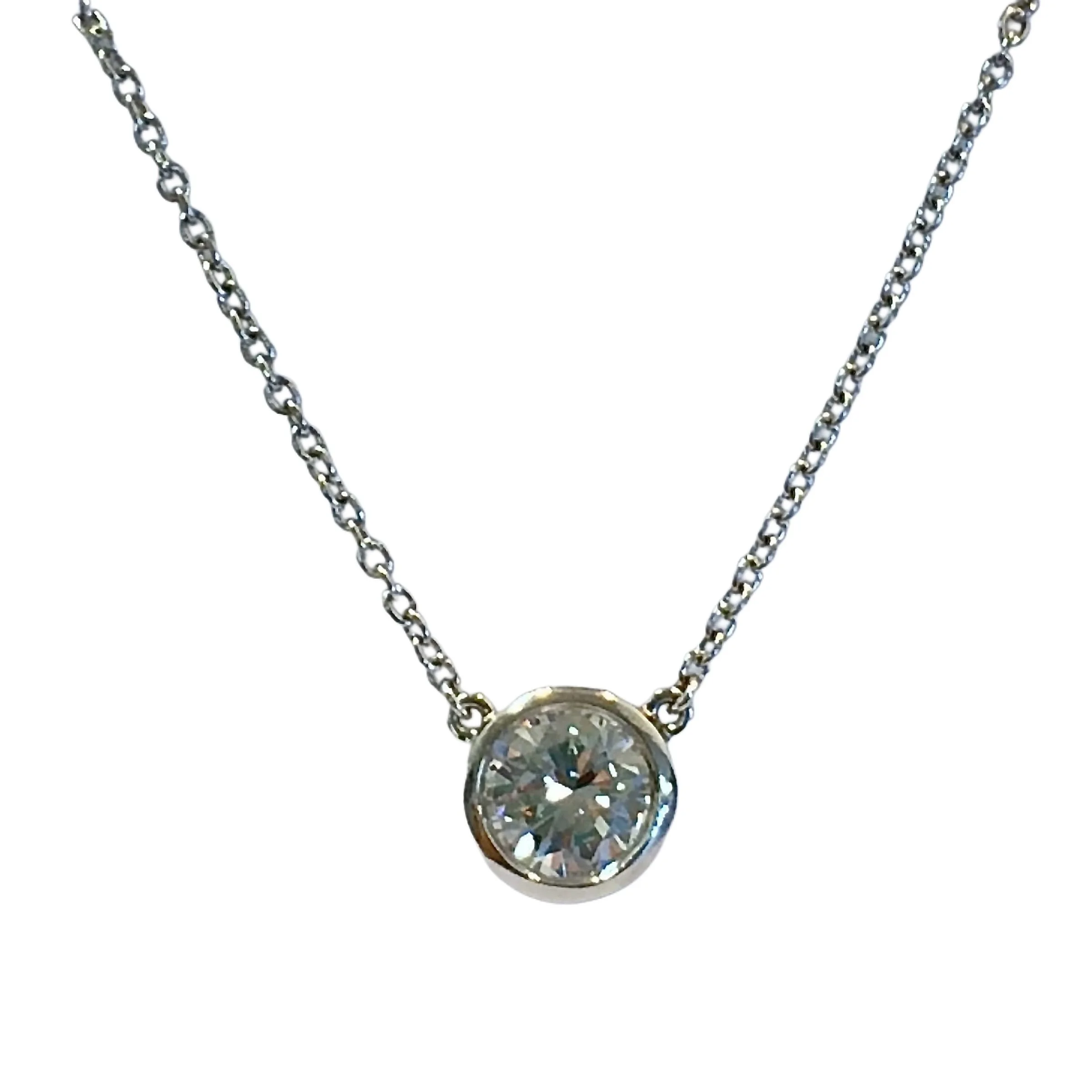 Heirloom Redesign- A classic solitaire platinum diamond pendant necklace featuring a round brilliant cut diamond in a bezel setting suspended from a 14 white gold.