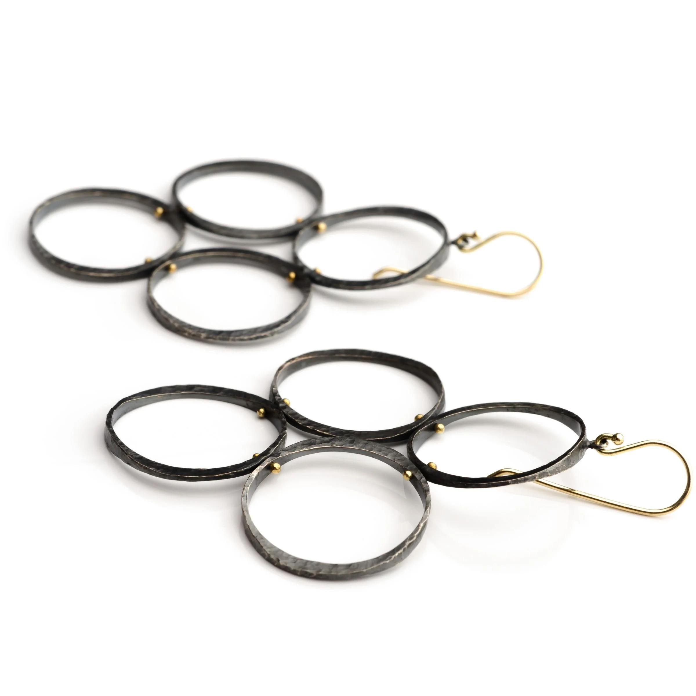 Sculptural dangle chandelier earrings showing cluster of black oxidized silver circles on 18k gold French ear wires