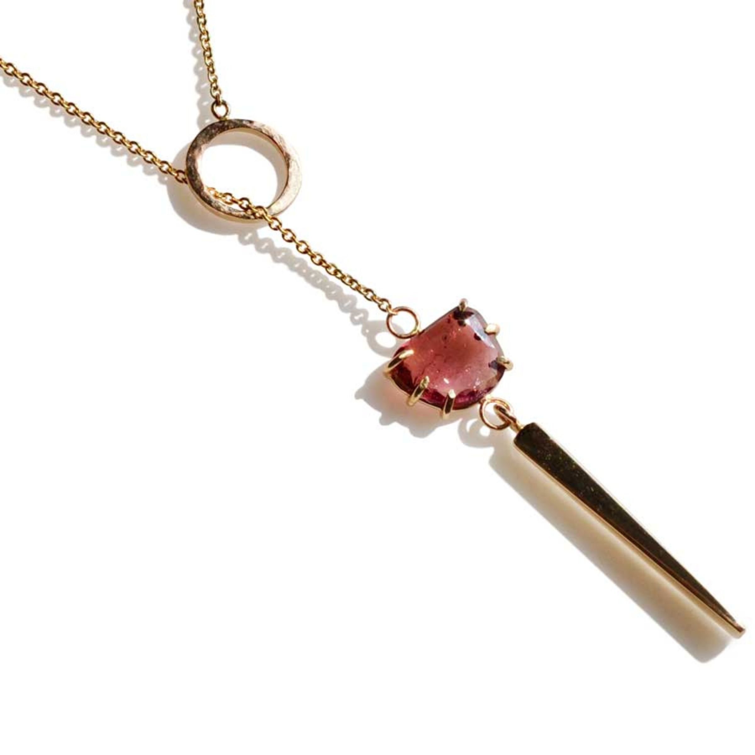 Handcrafted 14k gold lariat necklace with red tourmaline gemstone bar drop on 20-inch gold chain against plain background