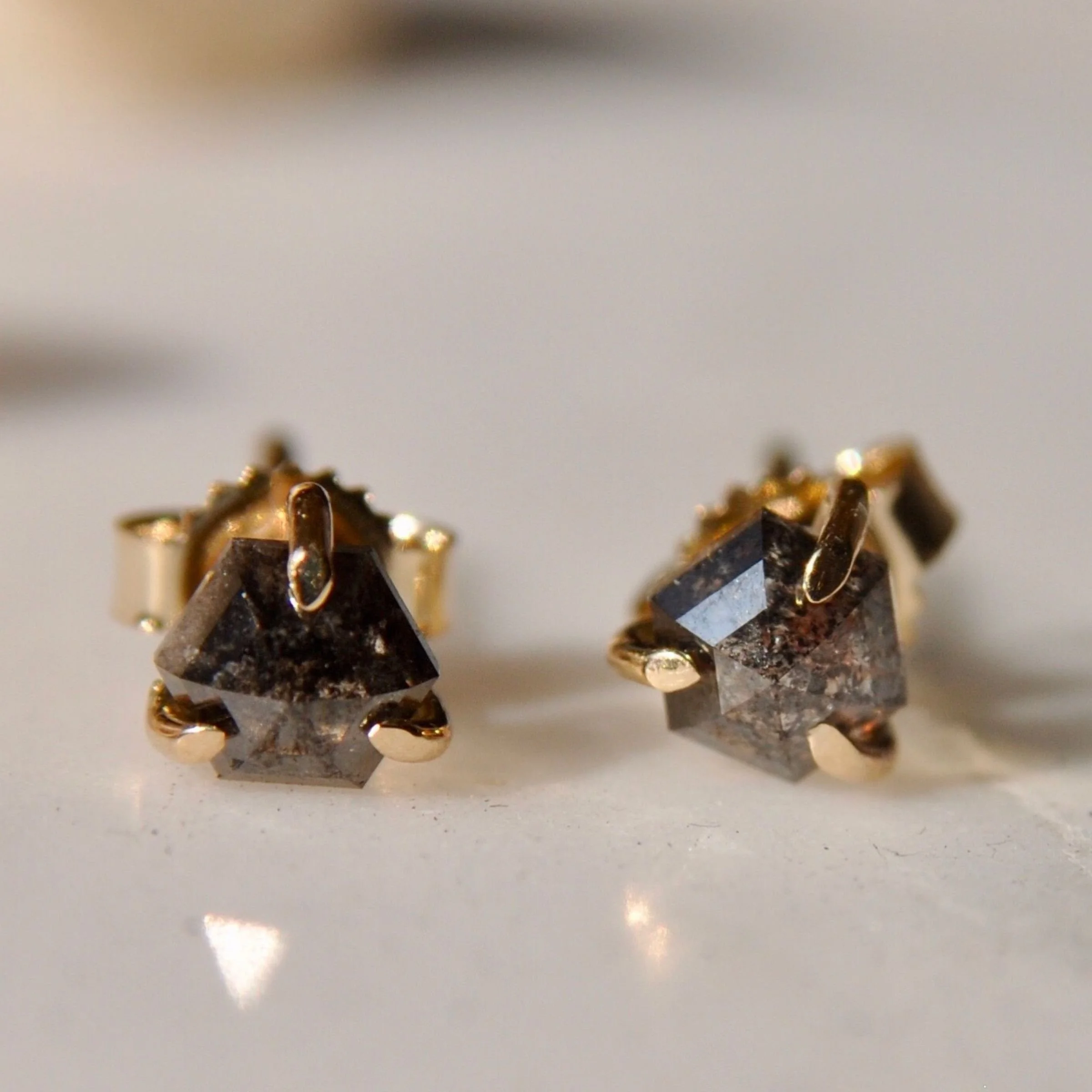 Modern 14k yellow gold hexagon-cut champagne diamond stud earrings featuring raw included diamonds in a minimalist three-prong claw setting