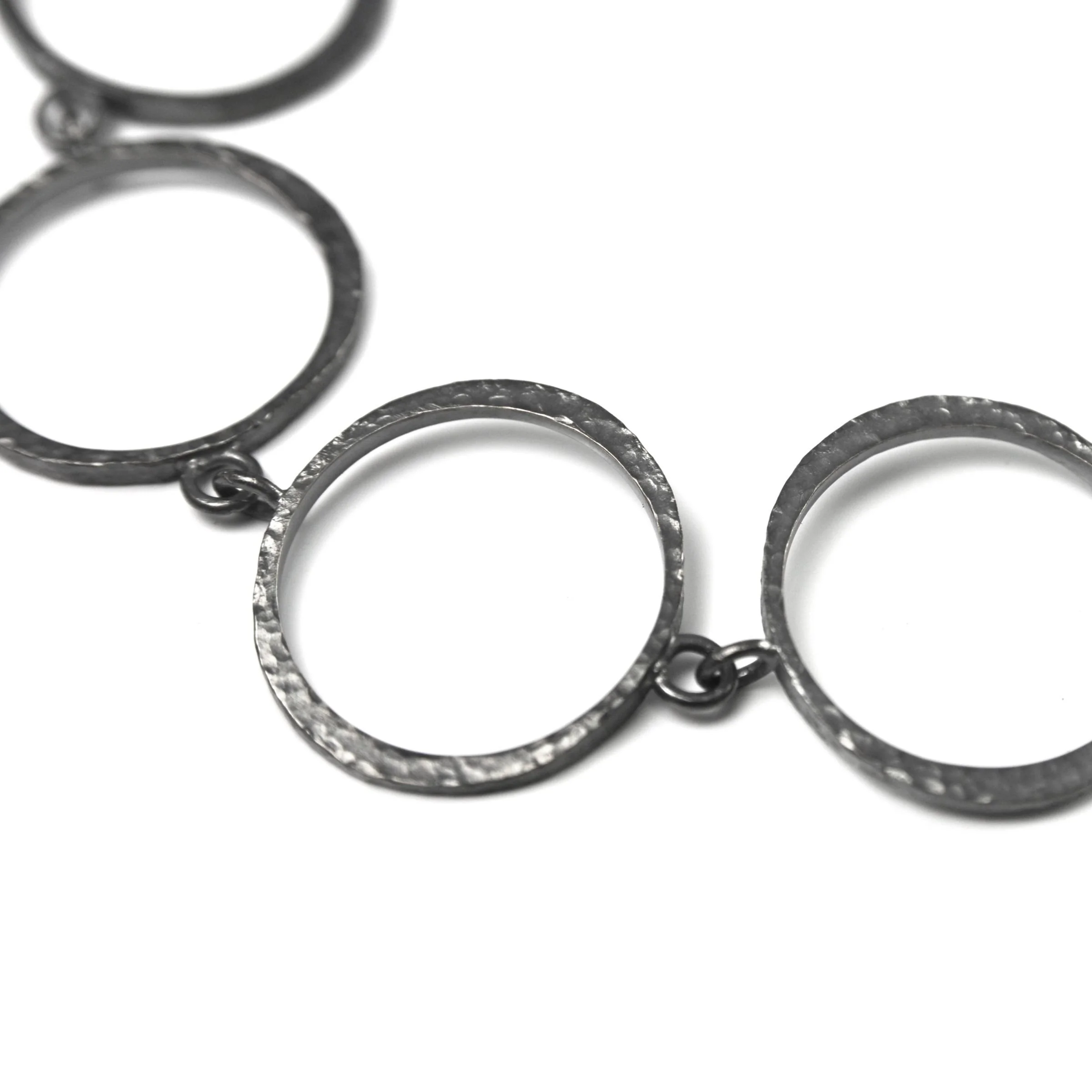 Handcrafted dark patinated sterling silver mini circle link bracelet showing forged pigtail catch closure