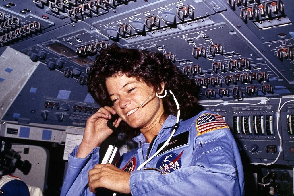 1024px-Sally_Ride,_America's_first_woman_astronaut_communitcates_with_ground_controllers_from_the_flight_deck_-_NARA_-_541940.jpg