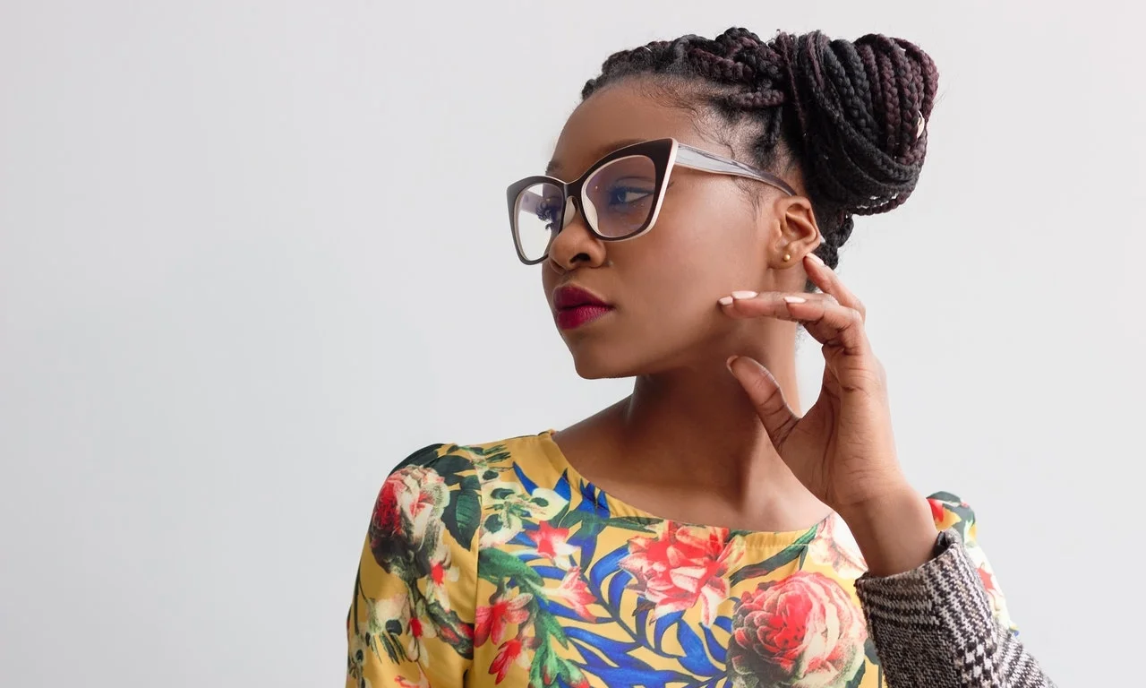 a Black woman professional wearing glasses and looking like she’s thinking